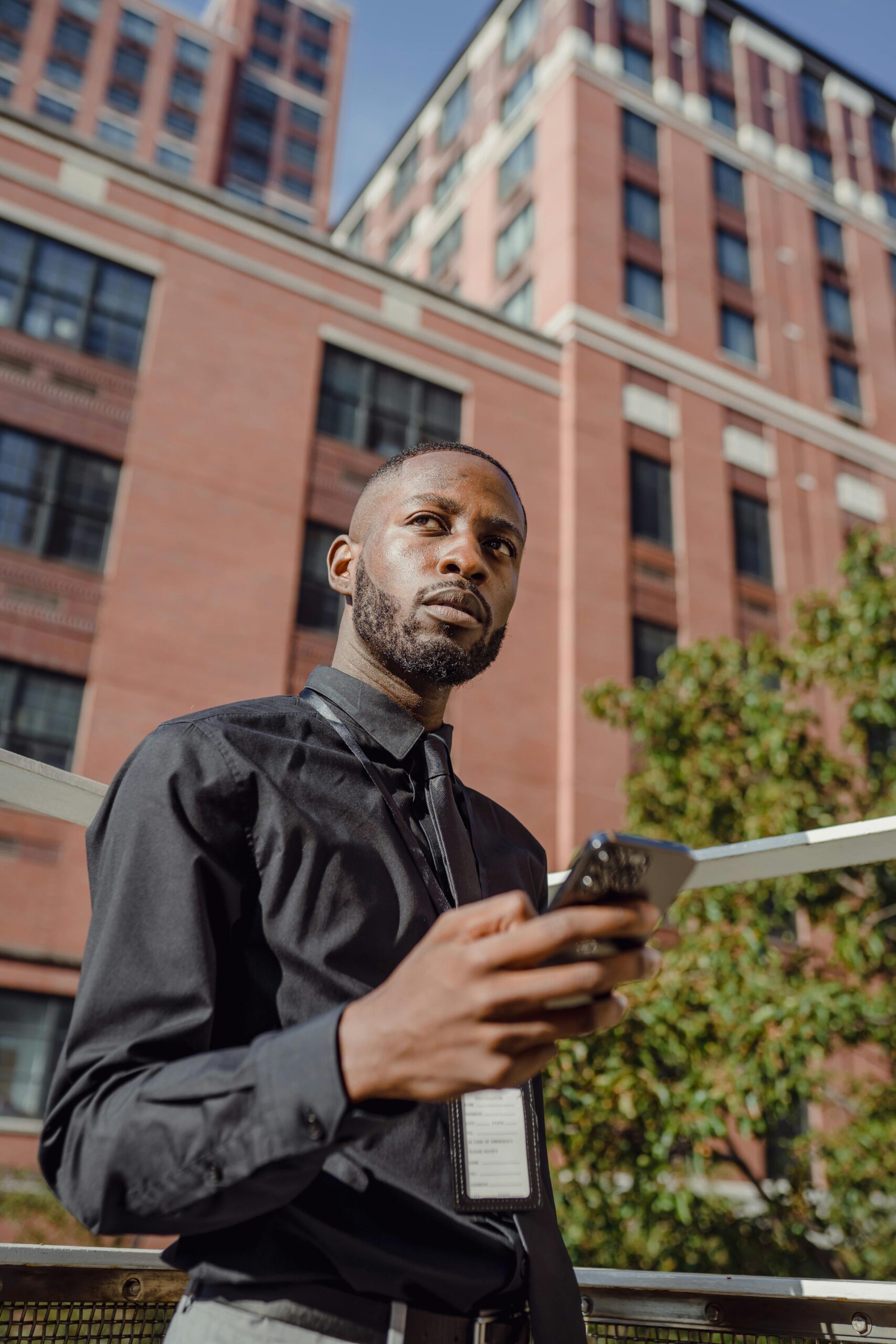 African American man in city using a smartphone, symbolizing modern urban lifestyle.